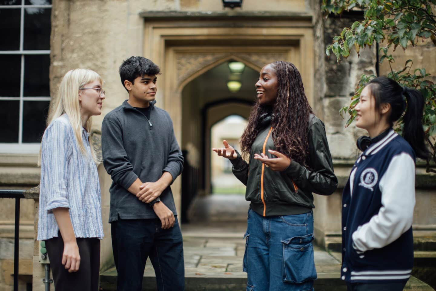 Four students standing in Grove Quad talking