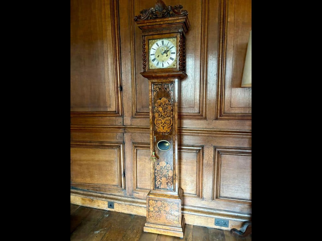 Photo of the Daniel Quare clock, against the wood panelling in the Lower SCR