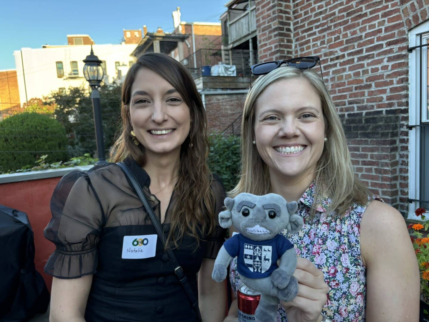 two alumna holding an imp at the DC toasts across the coasts