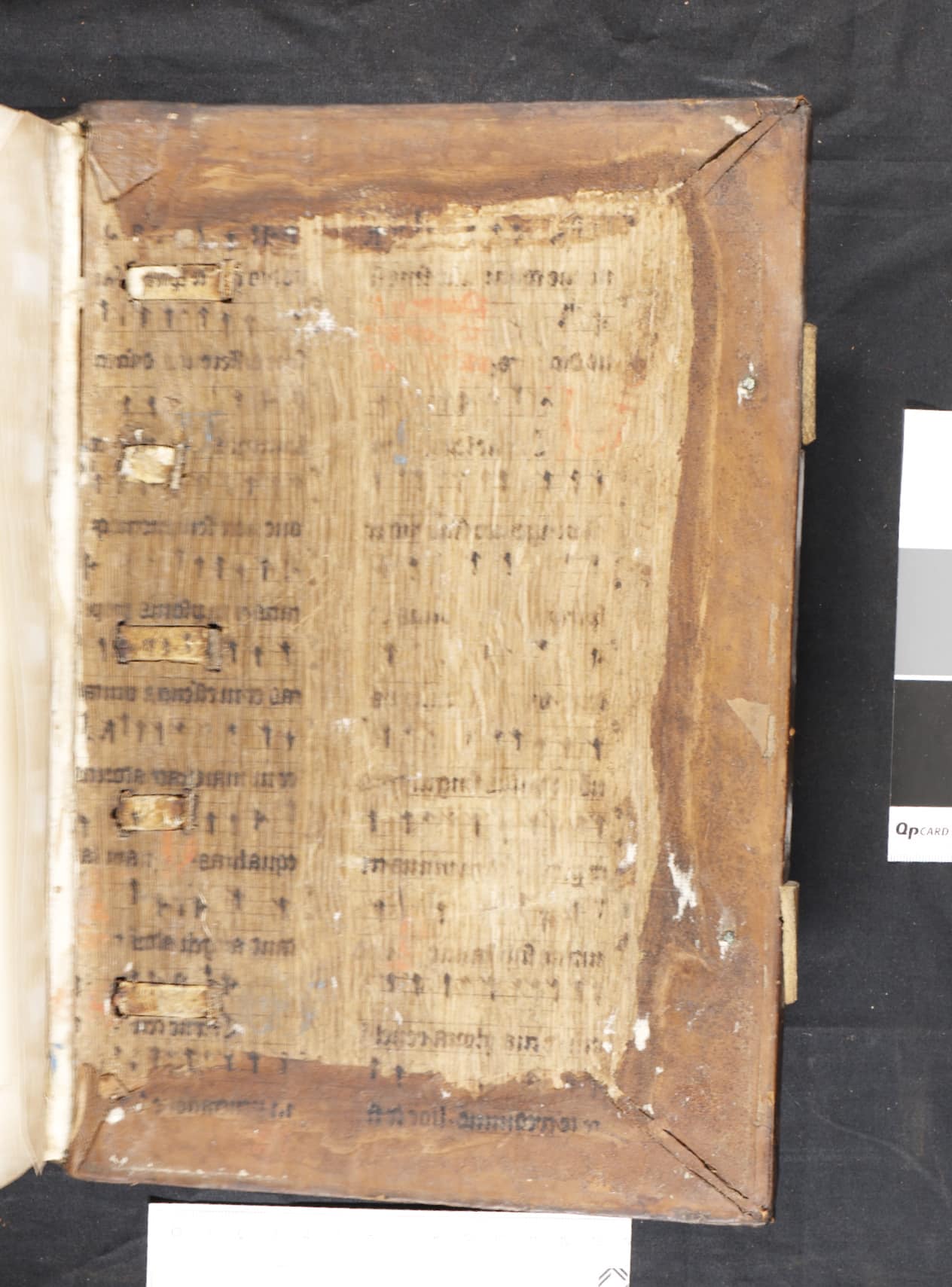 Remnants and ink residue from a leaf of a 14th or 15th century missal visible on the wooden board of the Biblia Latina