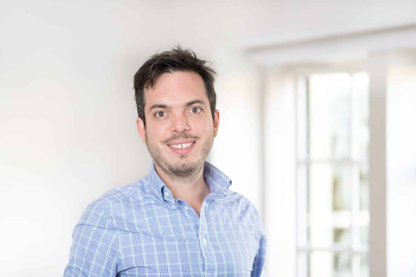Headshot of Ezequiel Gonzalez Ocantos, a man in a blue and white shirt