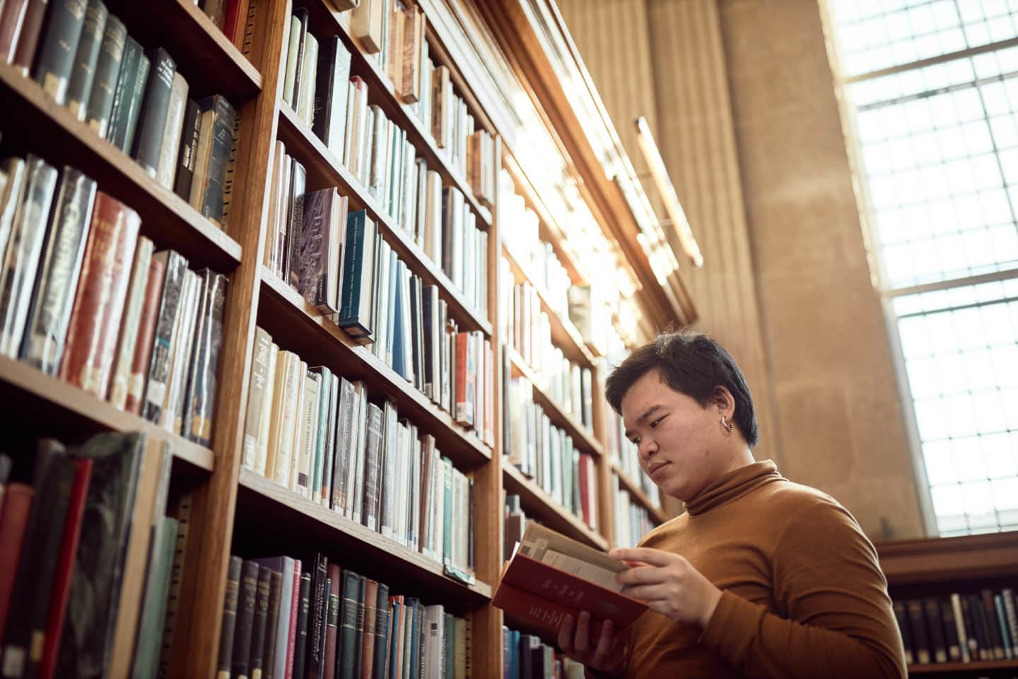 Lincoln student reading a book in the Library