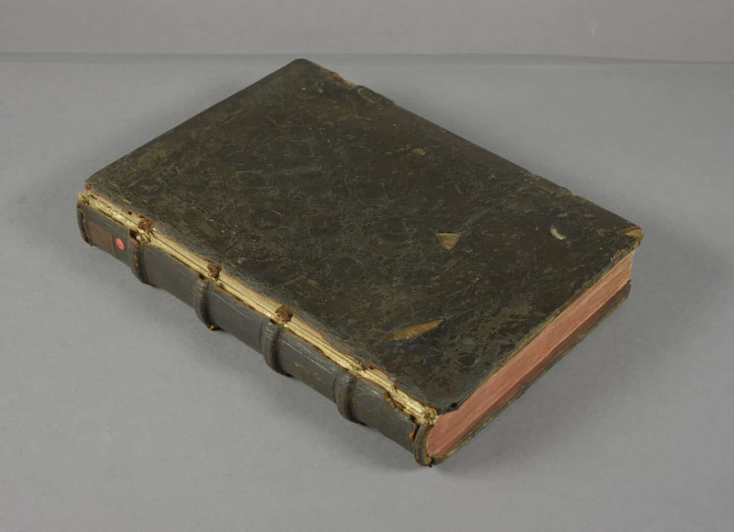 A closed 15th century book with leather binding over wooden boards