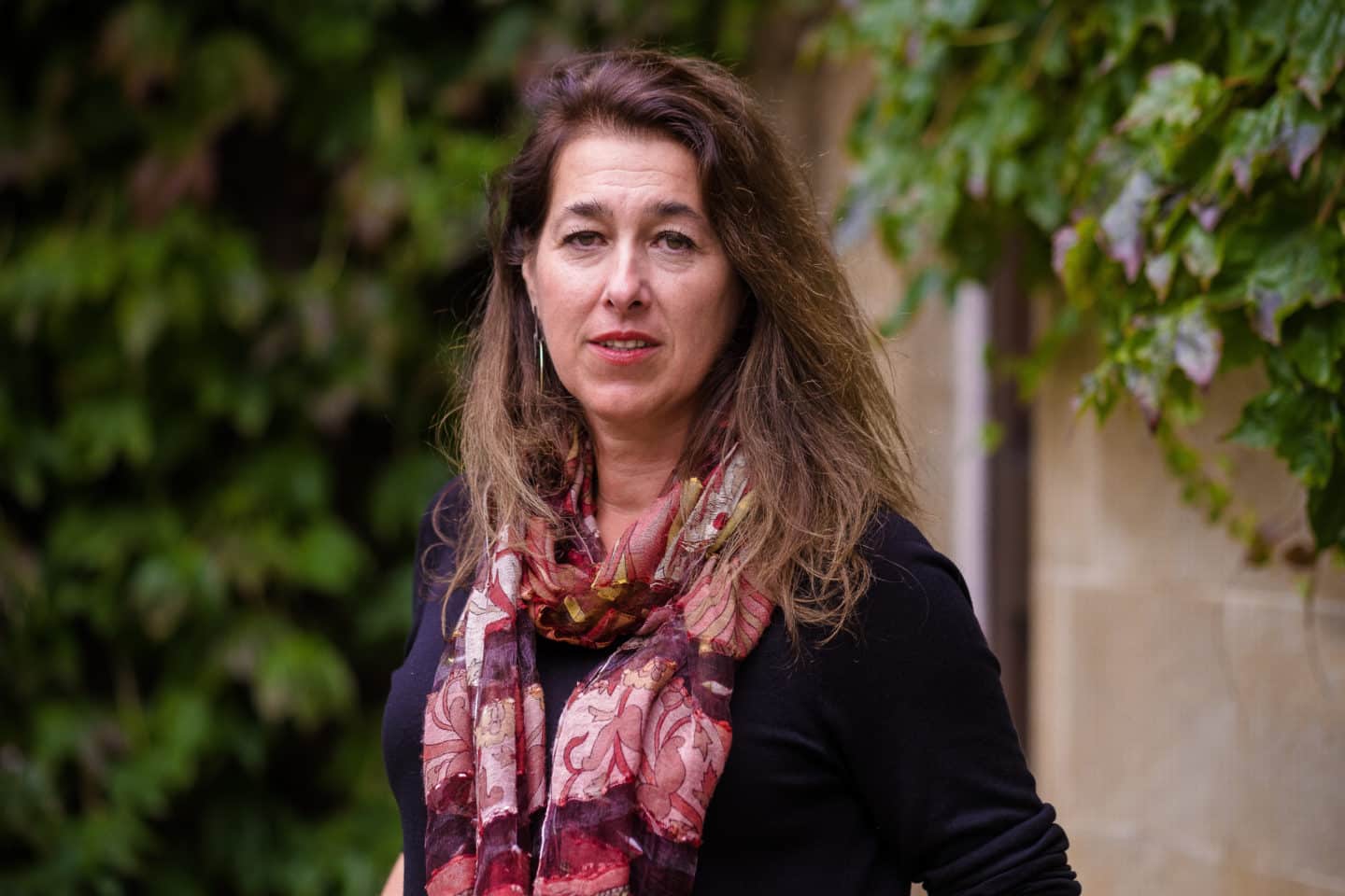 Headshot of Maria Stamatopoulou, a woman in a dark sweater and colourful scarf