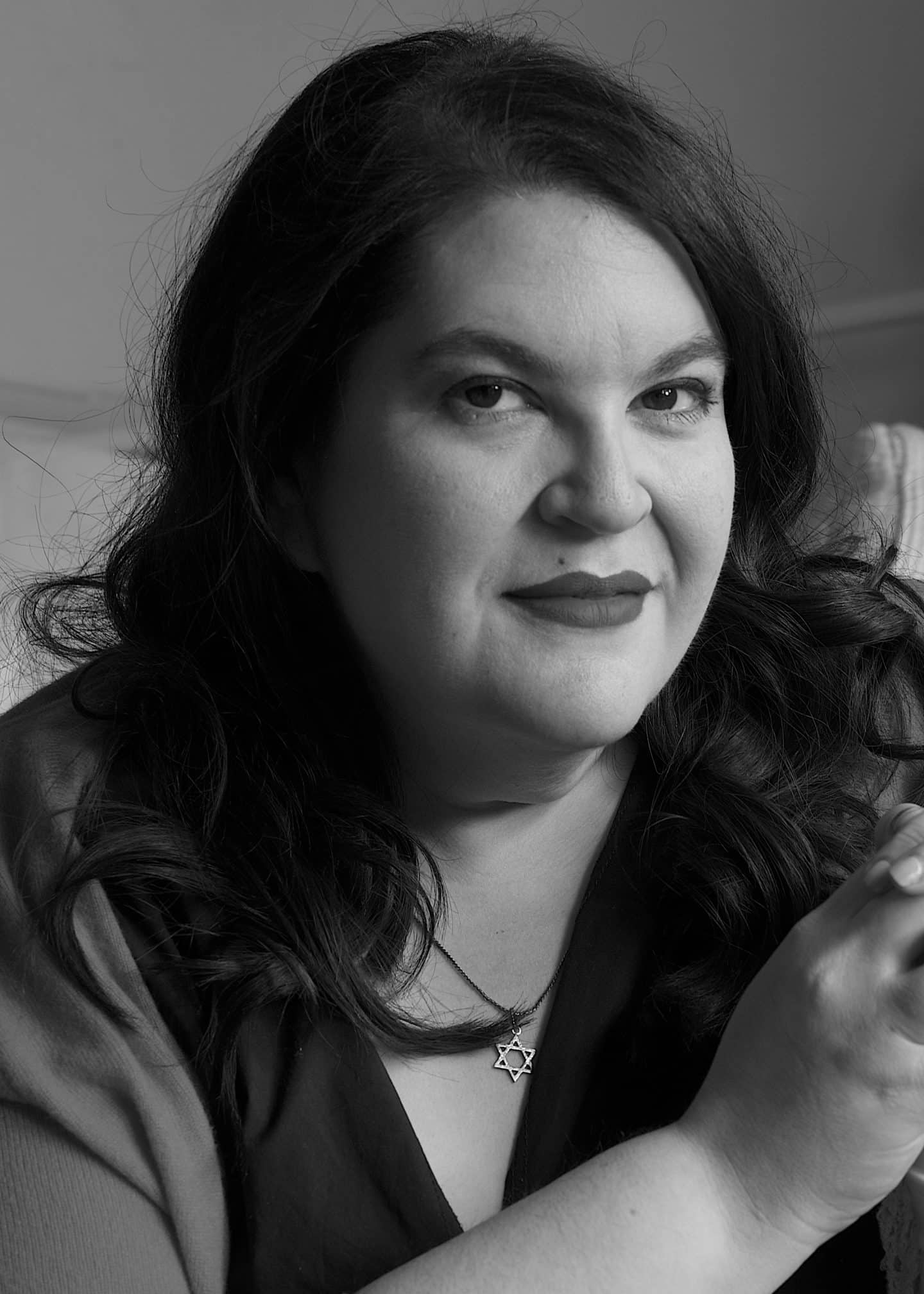 Greyscale photograph of Naomi Alderman, a woman wearing a Star of David necklace