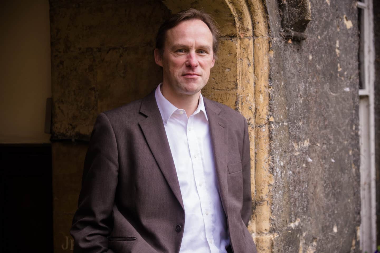 Heaadshot of Professor Edward Nye, a man in a brown suit