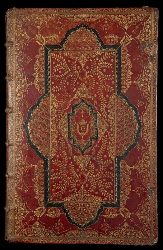 Book binding with sprays of gilt-tooled flowers and leaves against a backdrop of red goatskin (morocco) and black inlay.